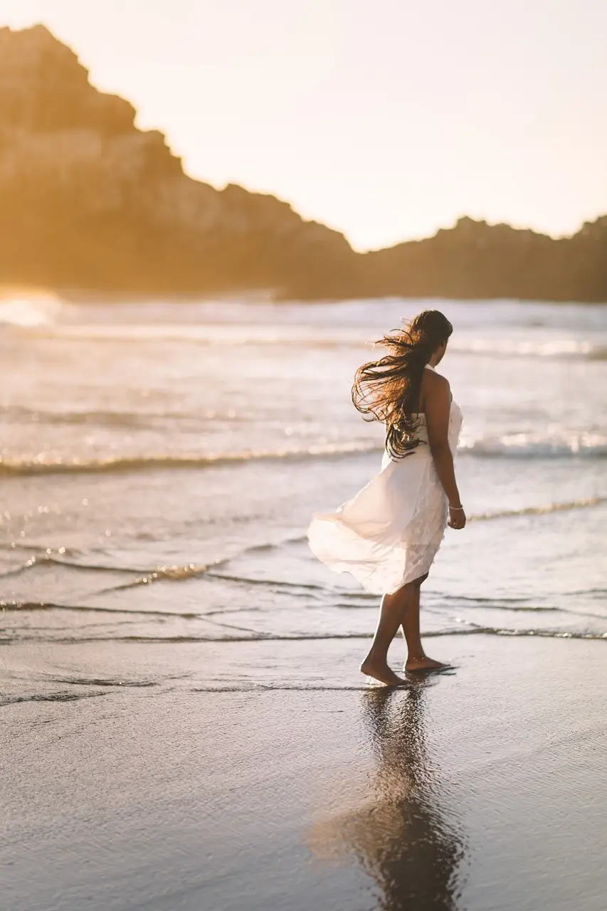Woman walking on beach enjoying overall physical and mental health