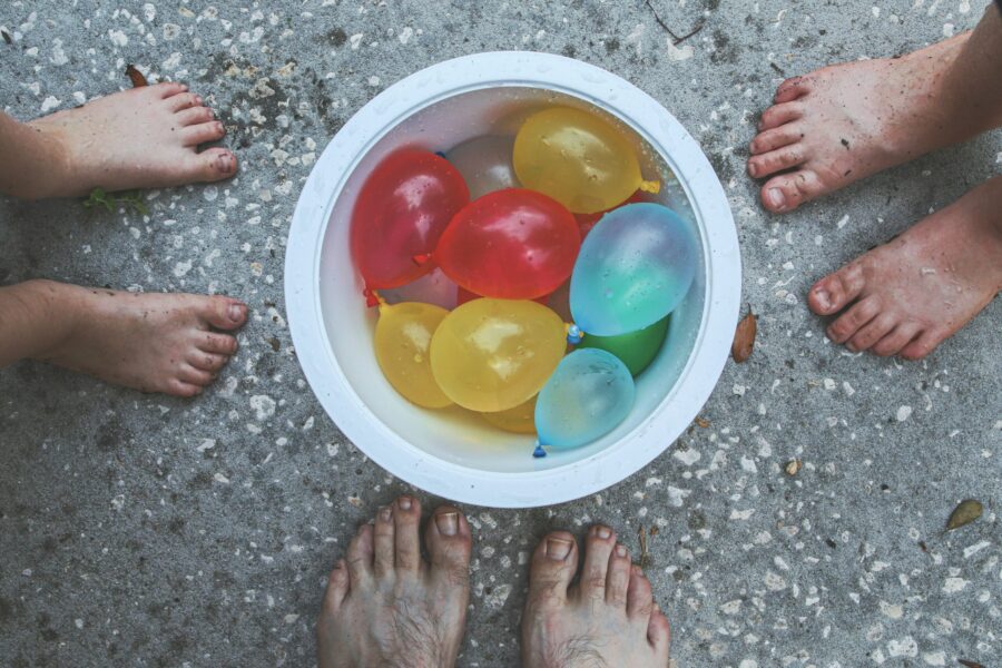 Kids standing around a bowl of water balloons getting ready for a splash party