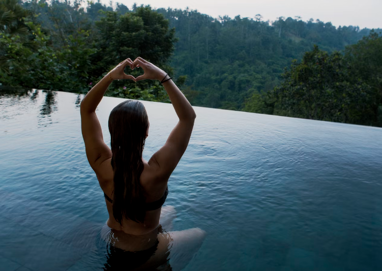 woman Sitting in pool at night overlooking a forest