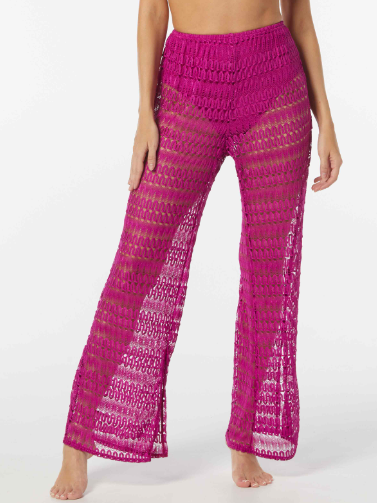 Woman wearing pink crocheted cover up pants after swimming