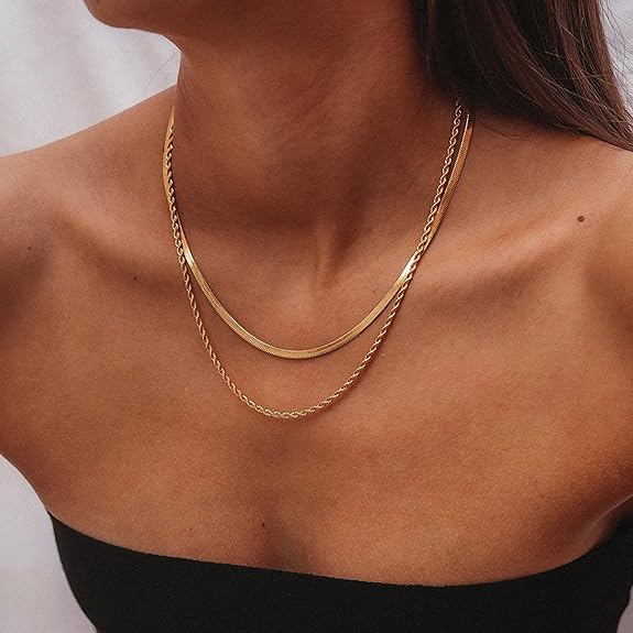 Woman wearing pretty layered gold necklaces ready for a swim waterproof