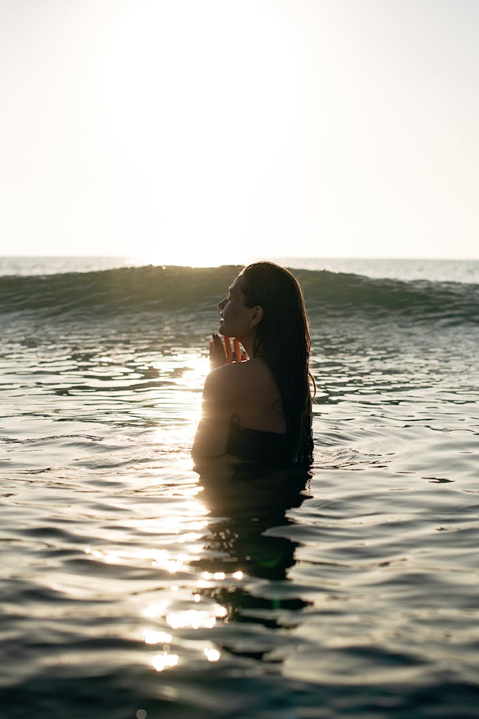 woman swimming peacefully in ocean at sunset