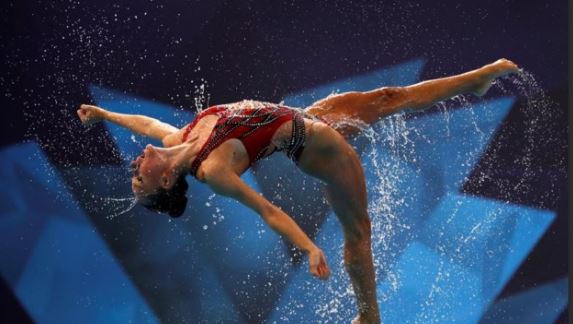 Artistic Swimmer doing an amazing turn in air above water