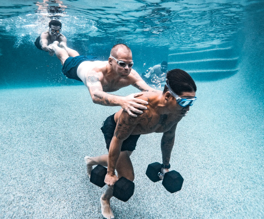 Two male athletes using the underwater fitness program to exercise using weights