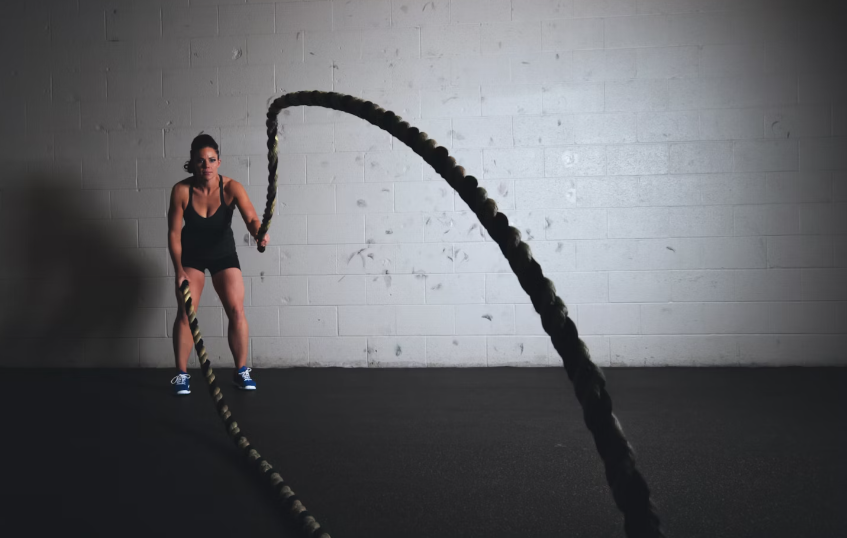 Female athlete working out using ropes looking healthy