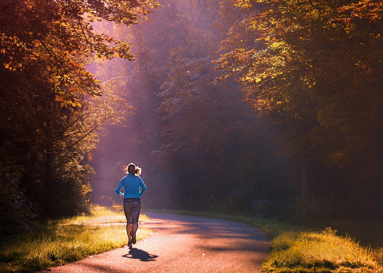 Woman running on path through the woods to exercise
