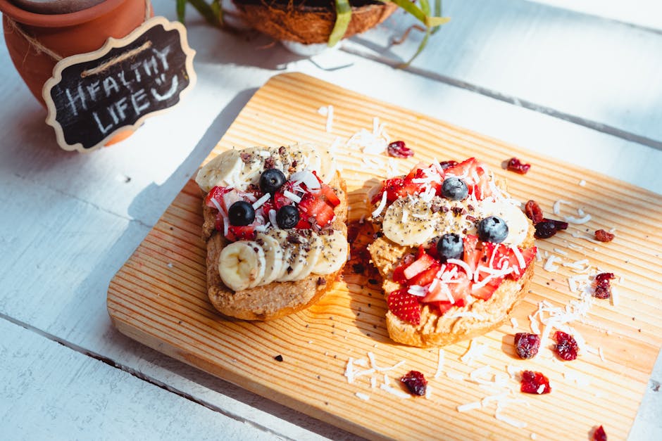 Delicious fruit-topped toast with banana, berries, and coconut on a wooden board, perfect for a healthy breakfast.