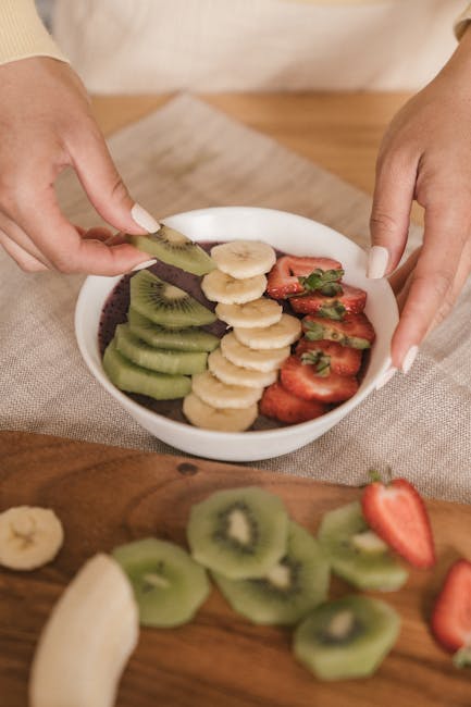 chia pudding bowl topped with fresh sliced fruits including banana, kiwi, and strawberries. Healthy lifestyle.
